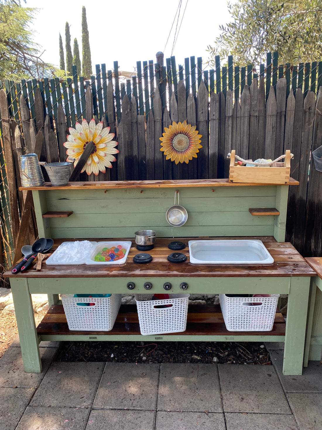 Green and redwood mud kitchen with shaving cream and water for sensory play