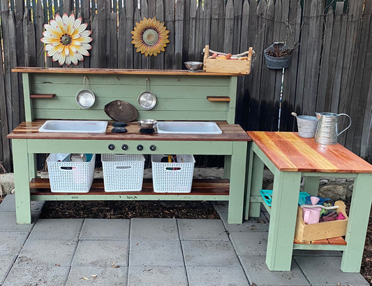 Painted green and Redwood mud kitchen set up in garden for outdoor imaginative play.
